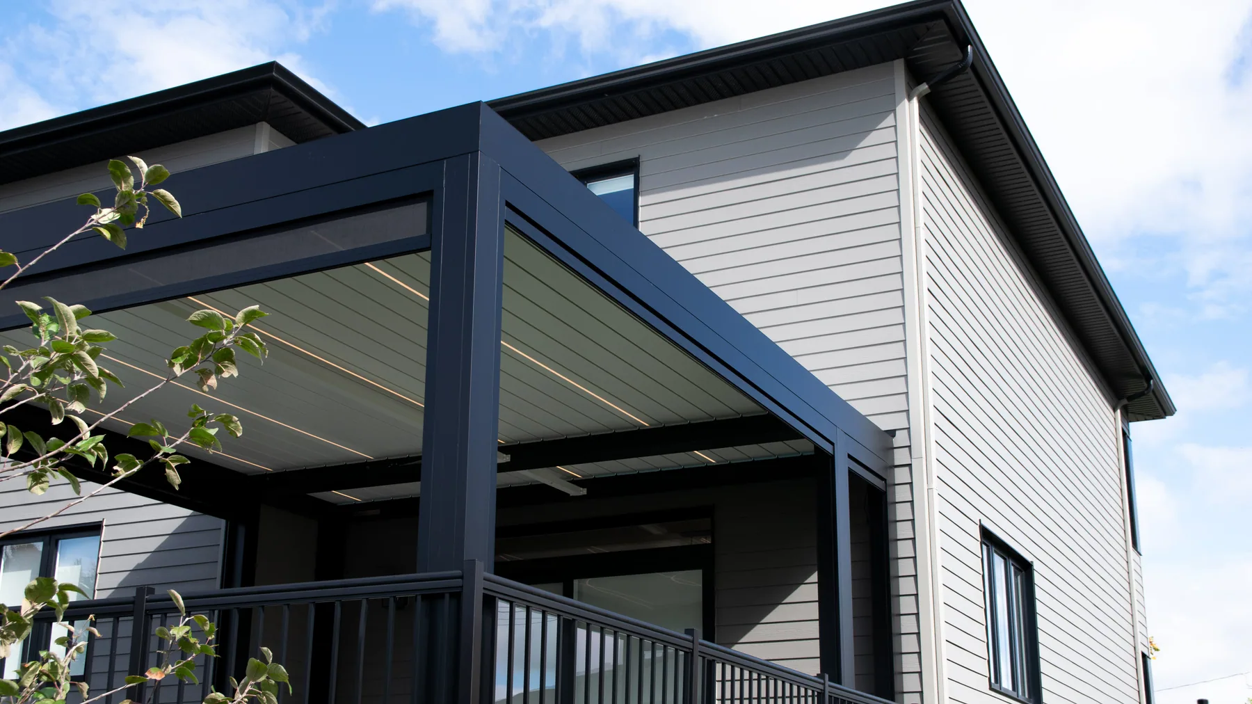 Pergola bioclimatique aux lames orientables ouvertes au-dessus d’une terrasse