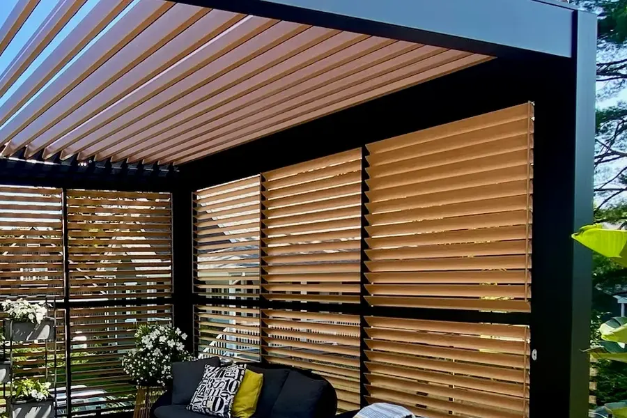 Panneaux de persiennes au fini imitation bois fermant l'arrière d'une pergola, lames de toit au-dessus