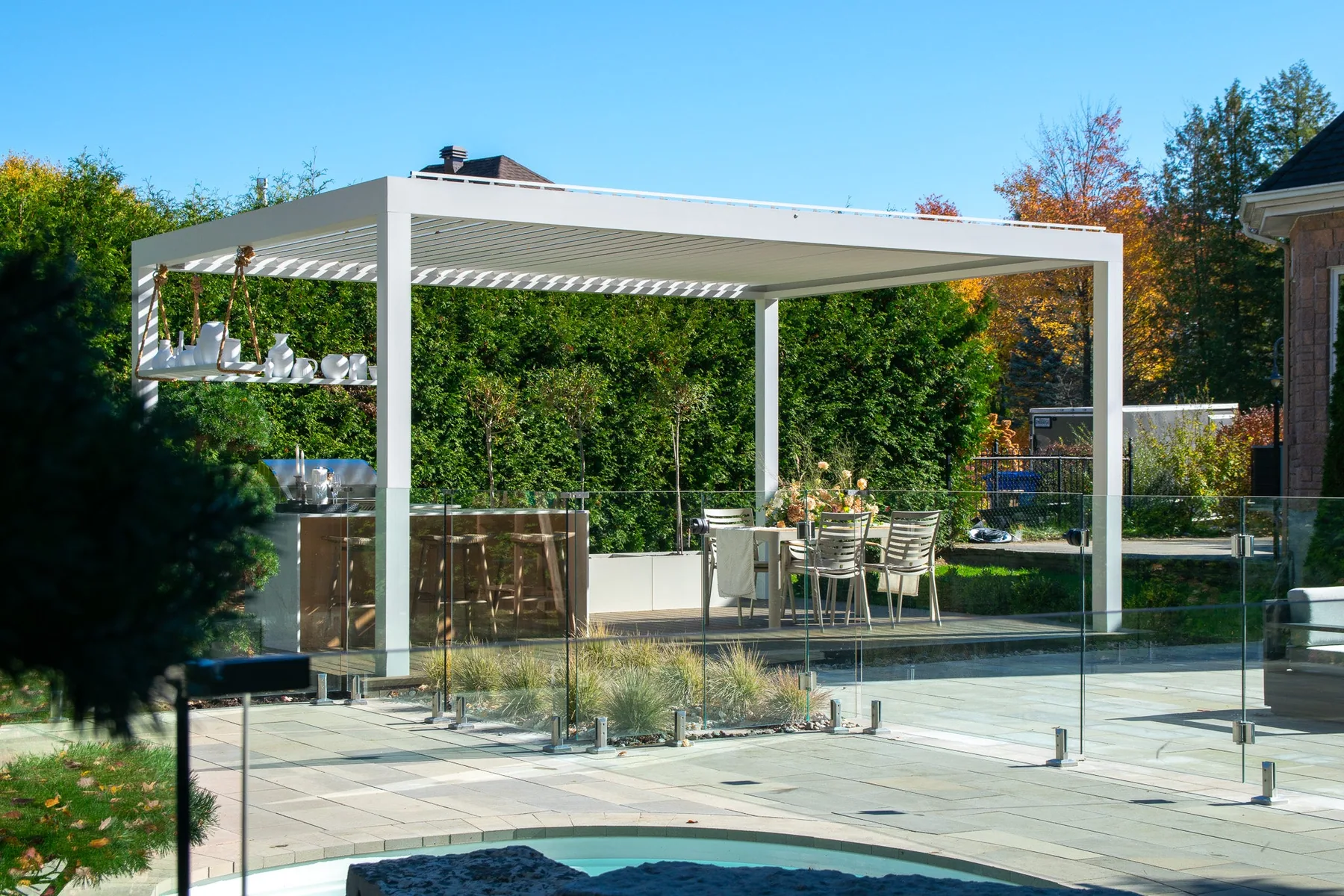 Pergola bioclimatique en aluminium avec lames orientables au-dessus d’une terrasse résidentielle