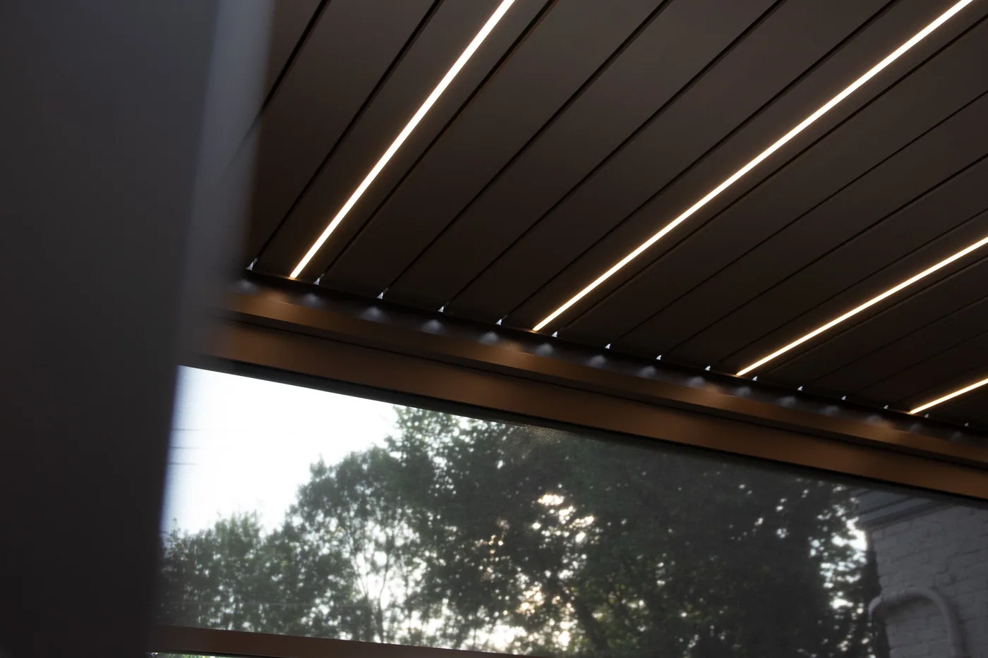 Pergola bioclimatique Provence de soir, éclairage LED allumé sous les lames orientables