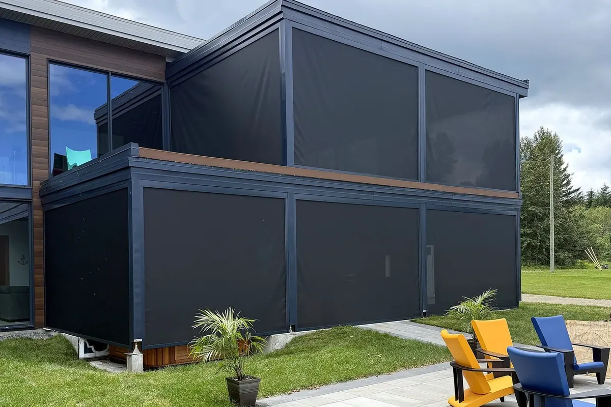 Toiles solaires motorisées abaissées sur les deux niveaux de la structure, agencées par couleur au revêtement — projet au lac Saint-François à Lambton