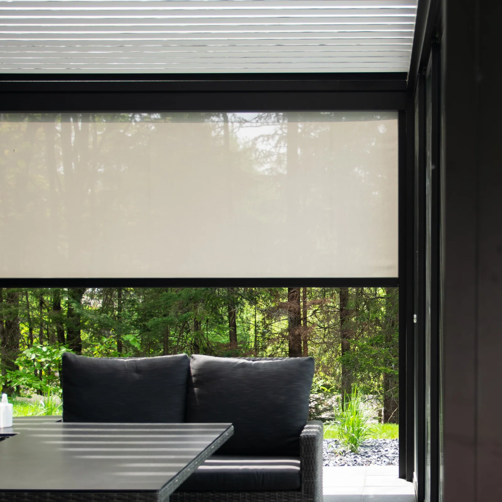 Motorized solar shade lowered along the side of a bioclimatic pergola