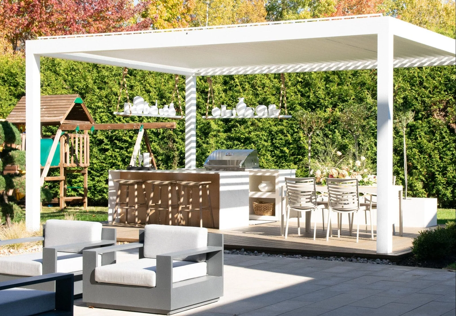 Vue d’ensemble de la terrasse : pergola Capri, cuisine extérieure et végétation.
