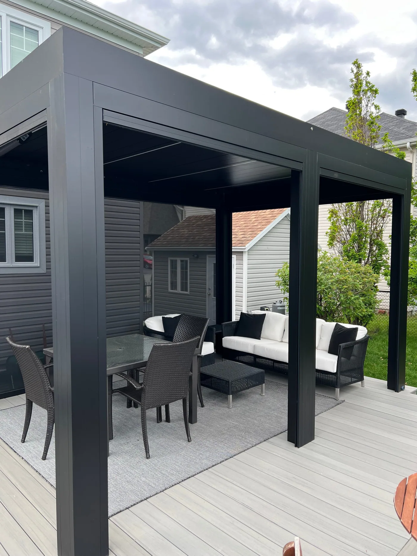 Outdoor lounge area beside the pool, under the Capri pergola