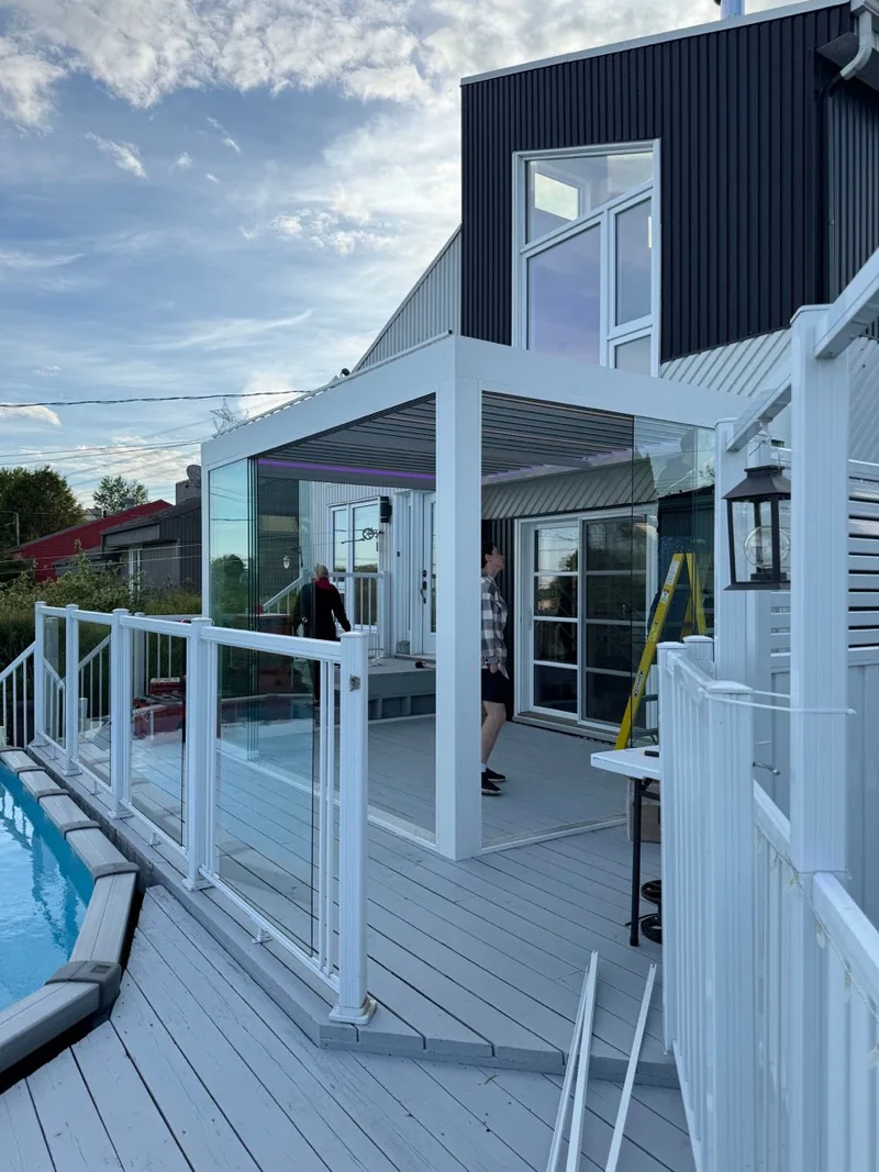 Pergola bioclimatique Capri fermée de verre coulissant, en remplacement d’un auvent, à L’Ange-Gardien