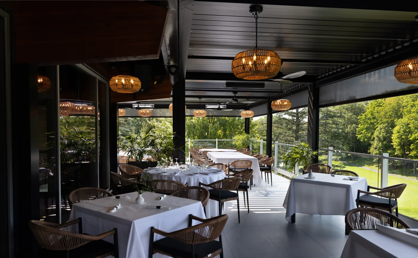 La même terrasse, toiles remontées : le soleil passe entre les lames et dessine des raies sur le plancher