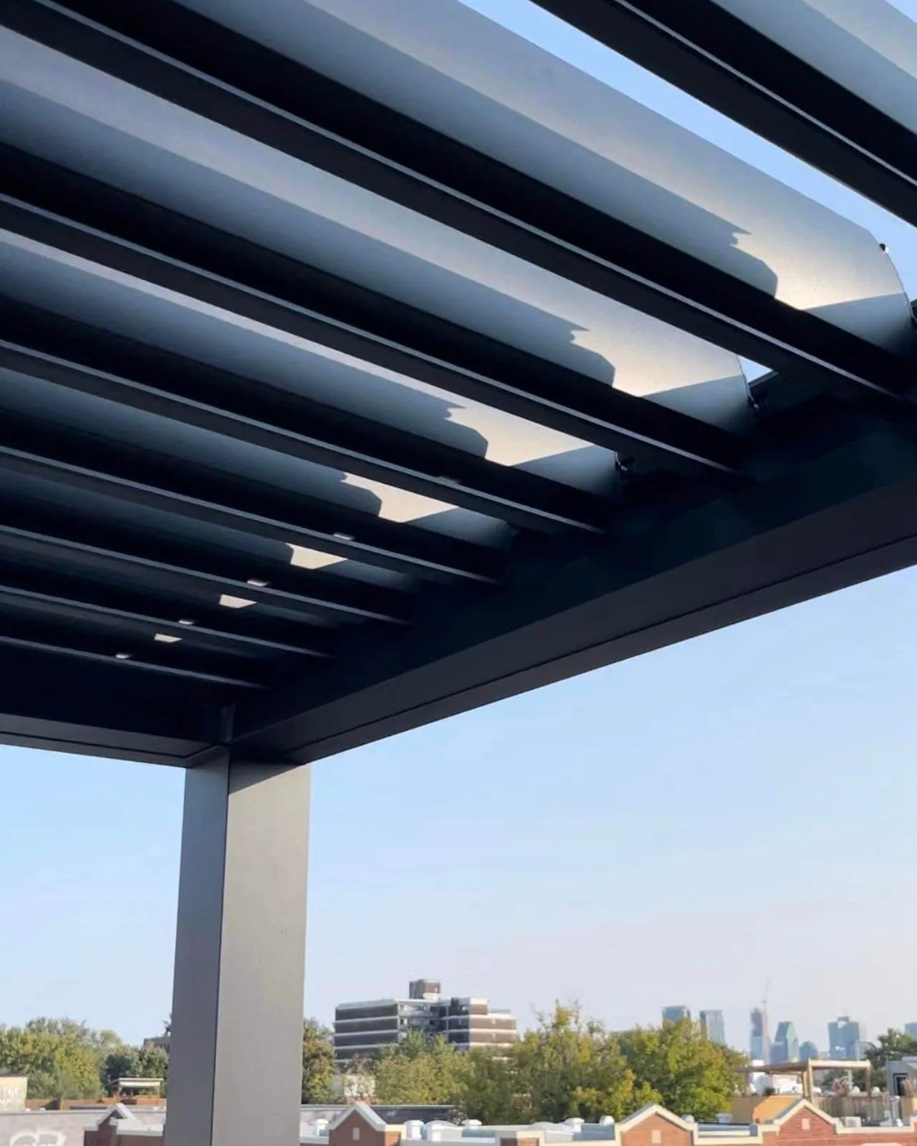 Black aluminum structure and adjustable louvres of the pergola, Montreal urban patio