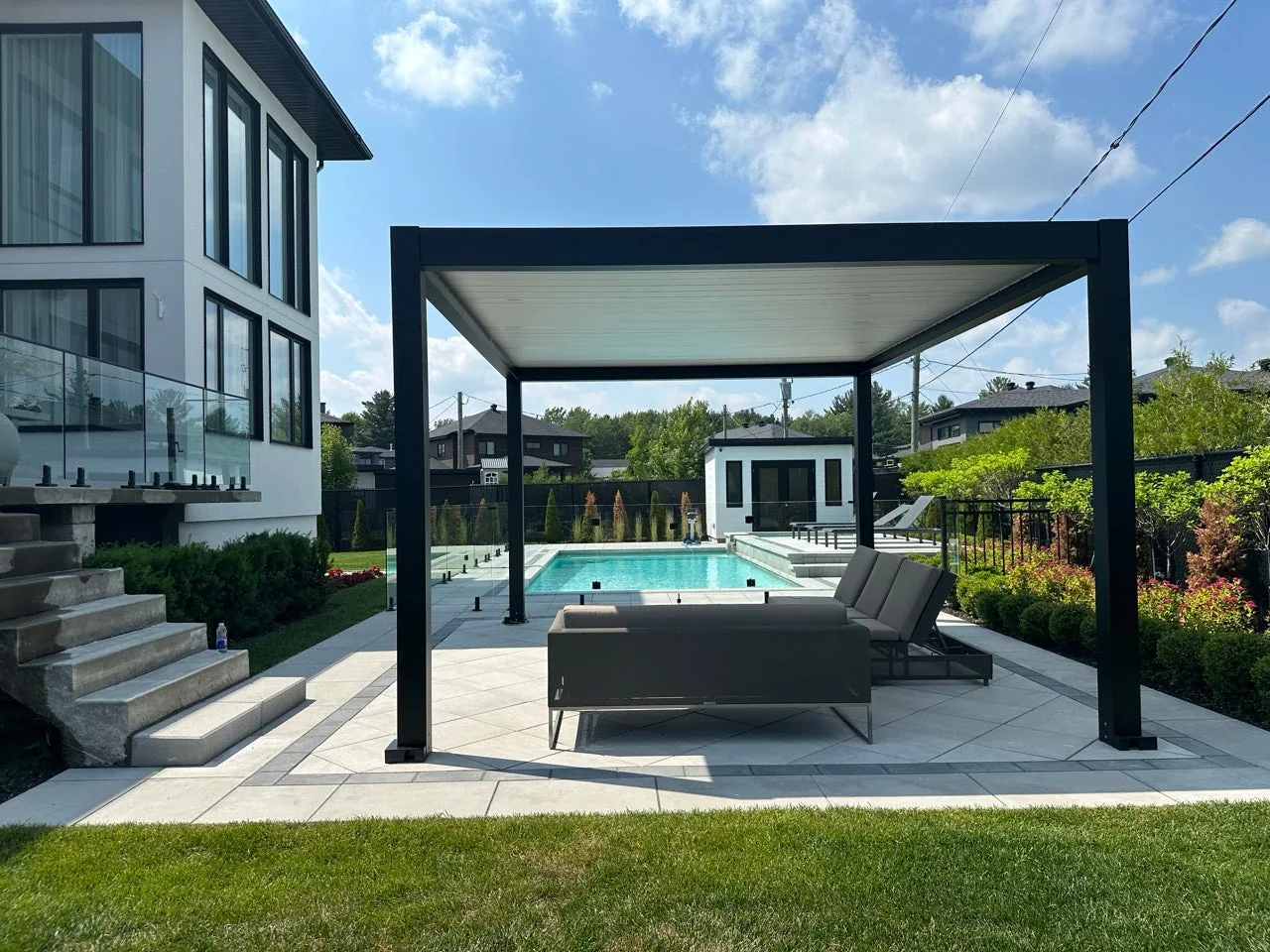 Espace lounge aménagé sous la pergola Provence, intégré aux dalles au sol
