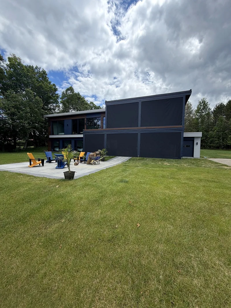 Espace de vie extérieur enveloppé de toiles extérieures motorisées, face au lac Saint-François à Lambton