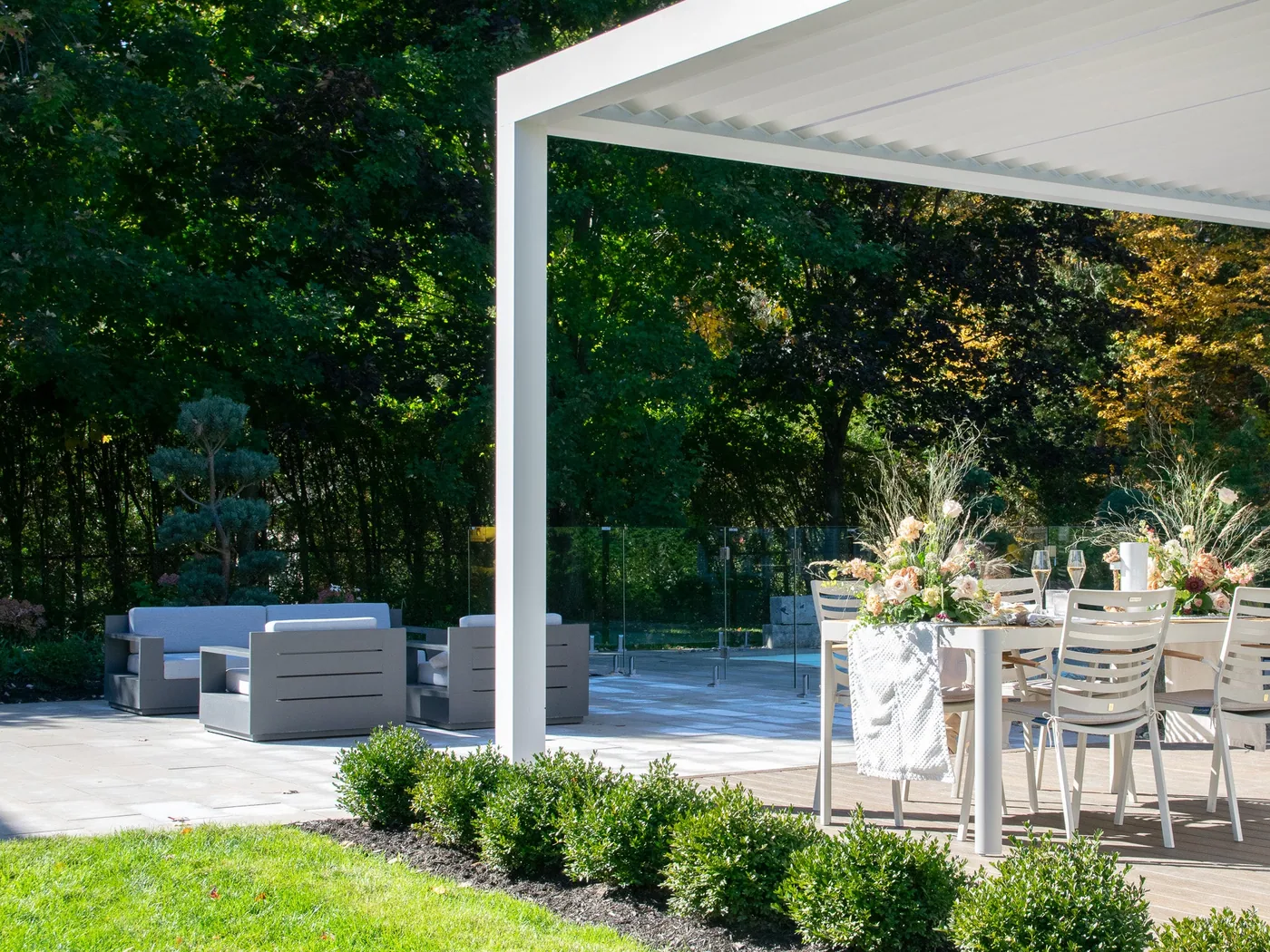 Outdoor kitchen of the Rioux project, with a grill, custom planters and wood-finish panels