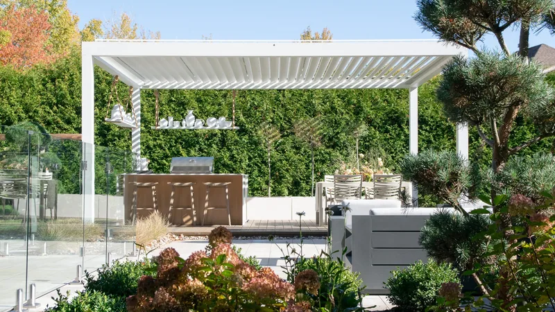 Pergola Capri autoportante et cuisine extérieure du projet Rioux, avec comptoirs Orastone couleur Chalk